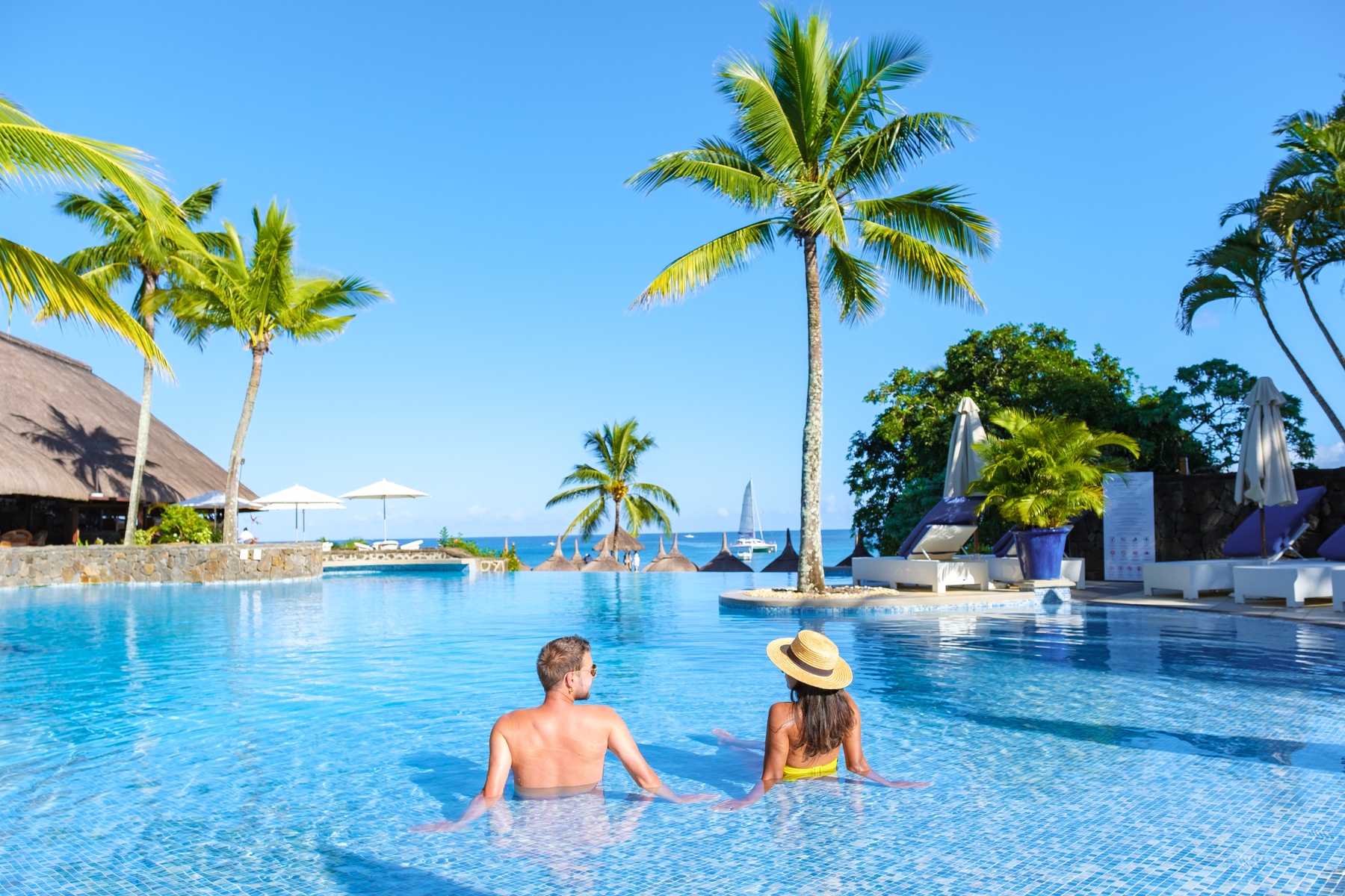 Man and Woman relaxing in a swimming pool in Mauritius. 