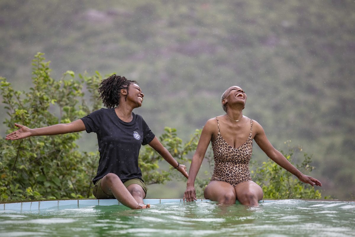 G Adventures tour guide and female traveler on edge of pool in Kenya.