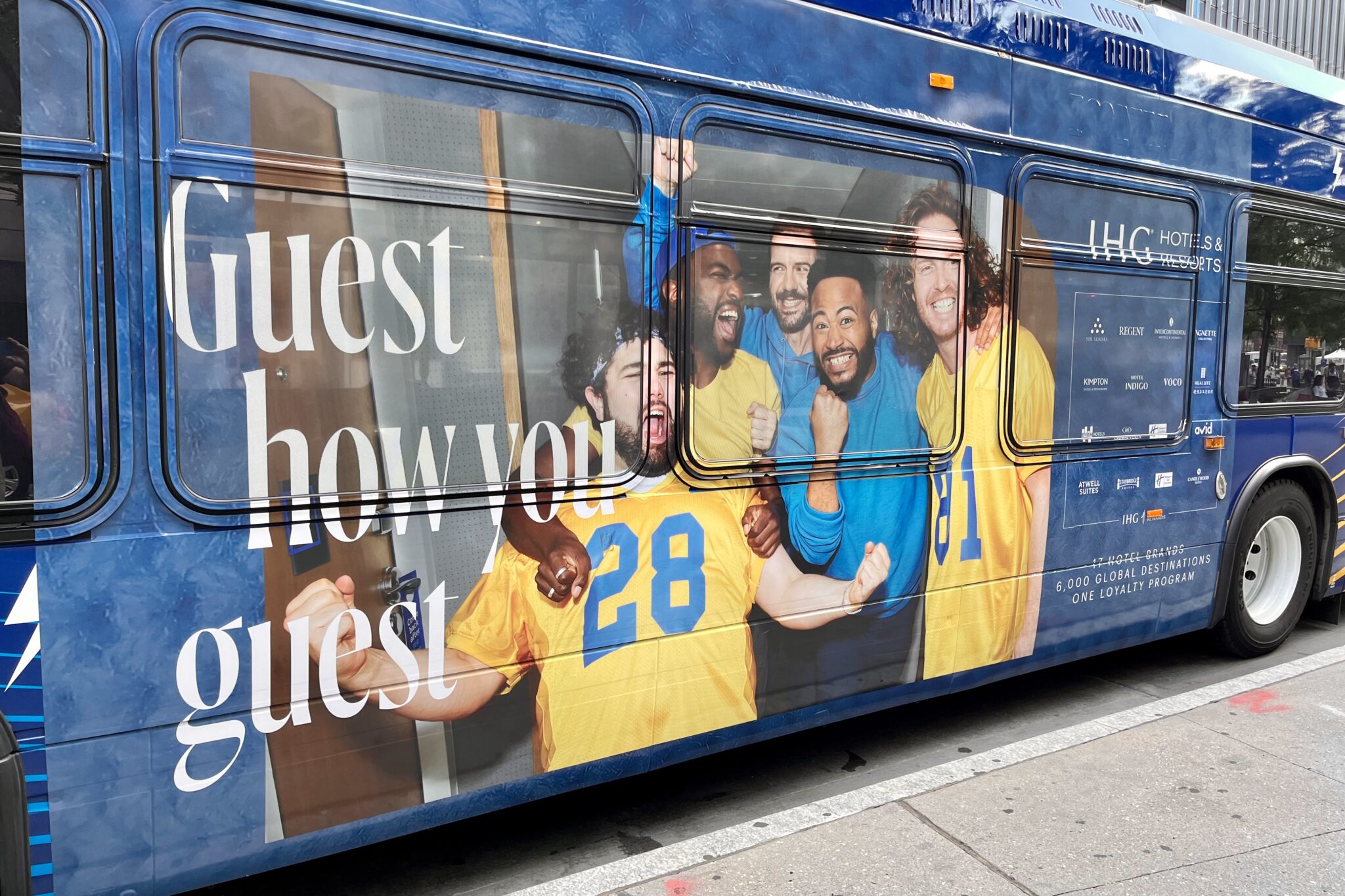 An ad for IHG's loyalty program on the side of a New York City bus. 